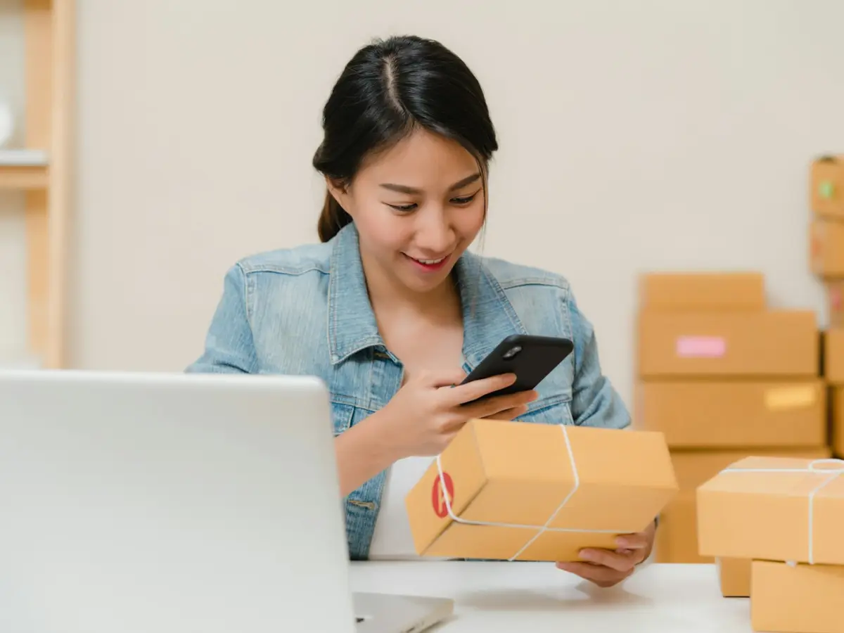 Shop owner checking an online order with packed boxes