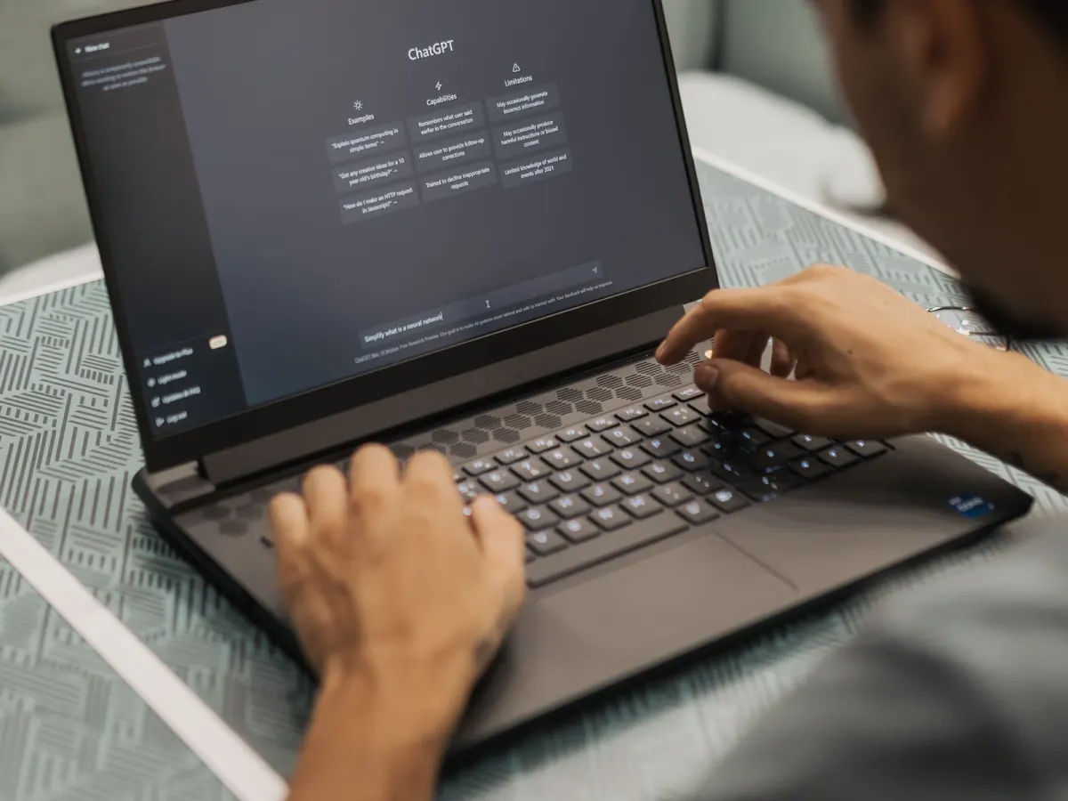 Person typing a question to an AI chat assistant on a laptop