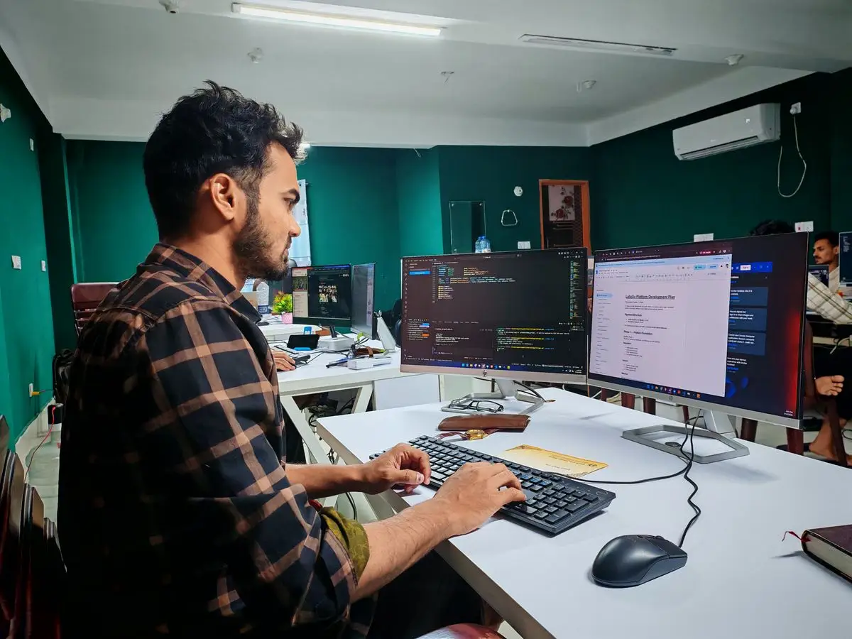 Developer writing code at a desk with two monitors