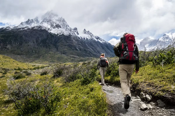 Trekkers with backpacks hiking on scenic mountain trail